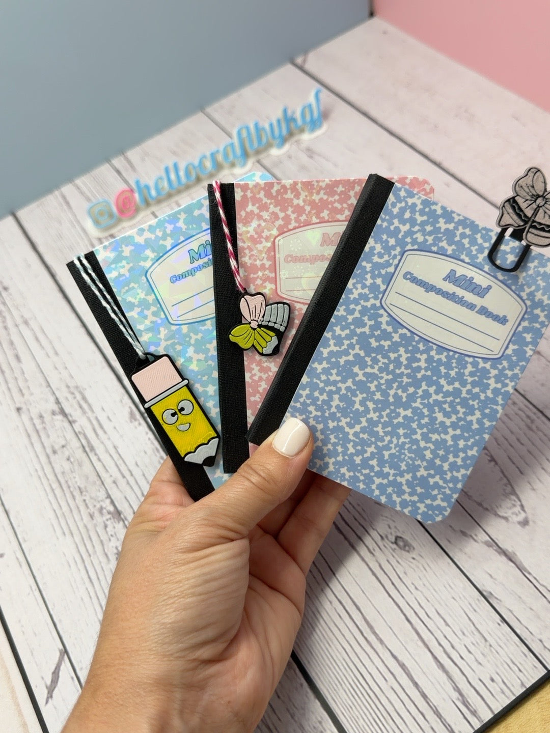 Three personalized mini composition notebooks with holographic covers and charms