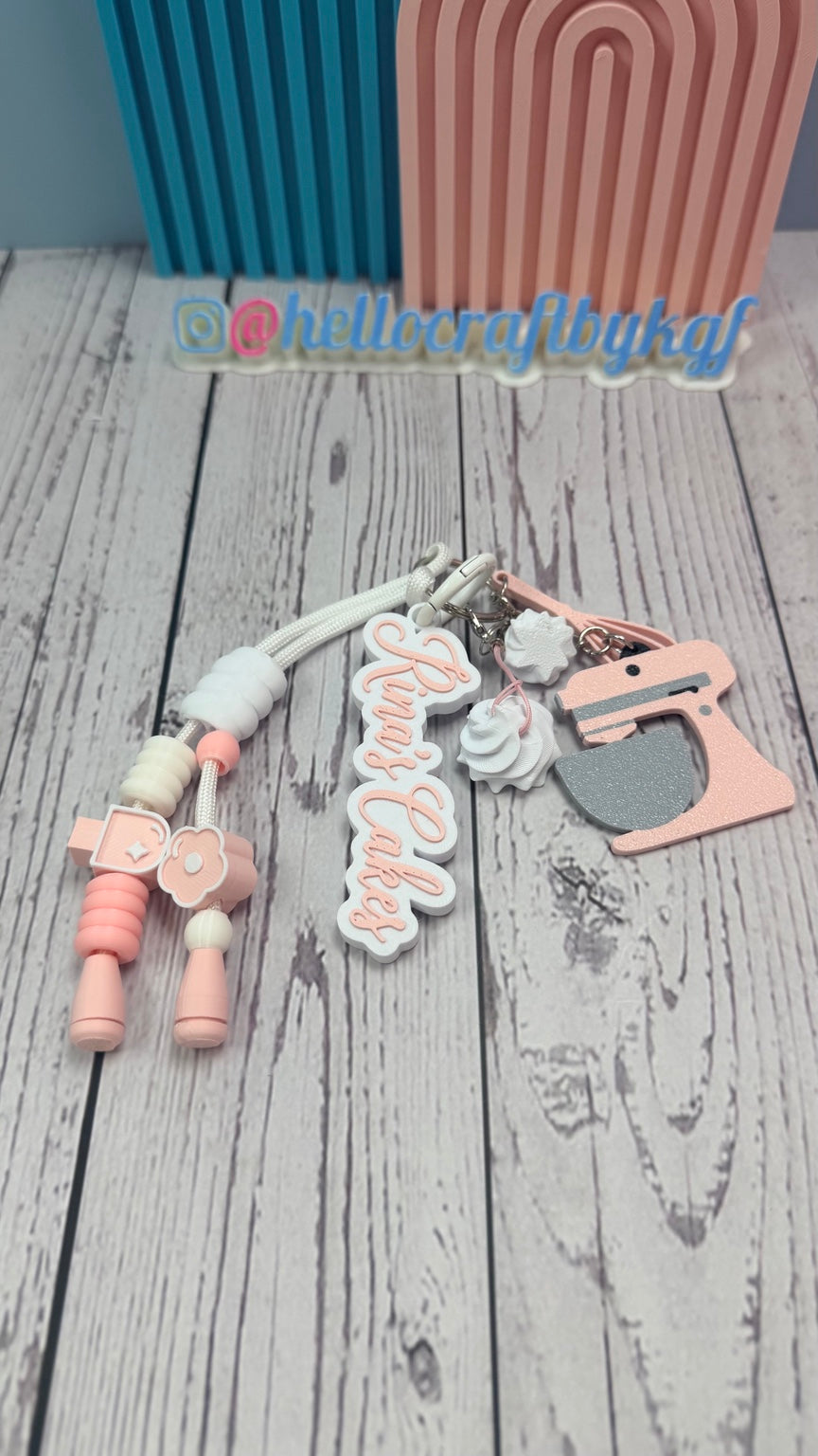 Close-up of personalized Sweet Baker keychain with pink stand mixer charm