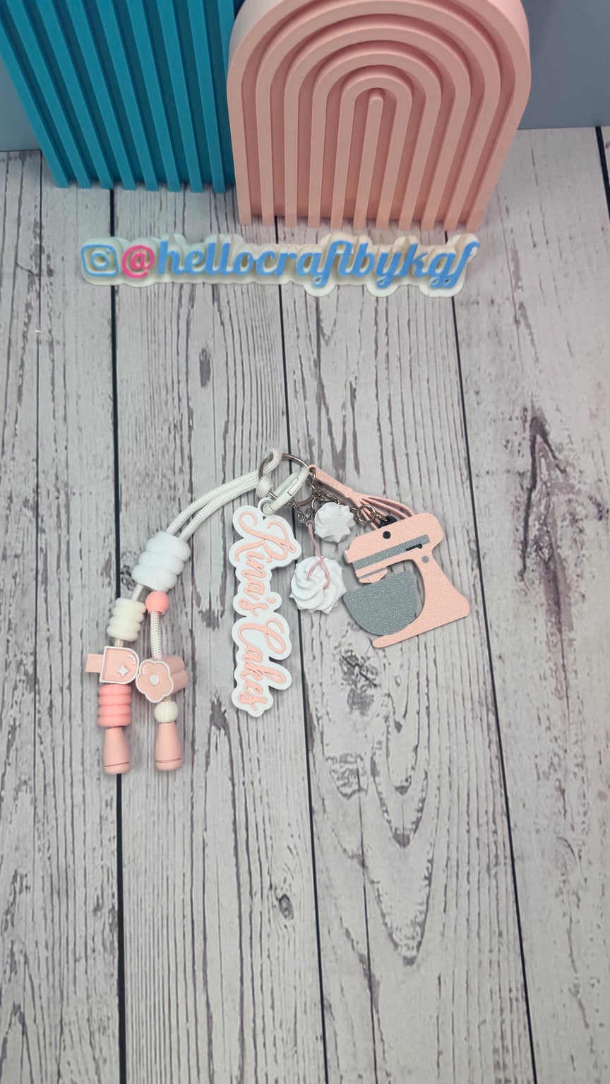 Top view of personalized baker keychain with pink and white charms